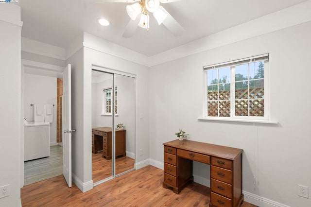 office area with washer / clothes dryer, ceiling fan, and light wood-type flooring