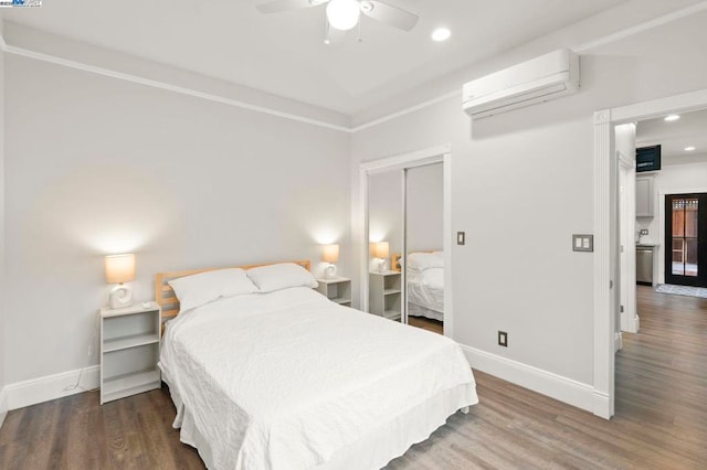 bedroom featuring hardwood / wood-style floors, a closet, a wall mounted AC, and ceiling fan