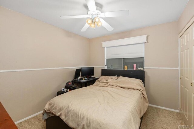 carpeted bedroom featuring a ceiling fan, baseboards, and a closet