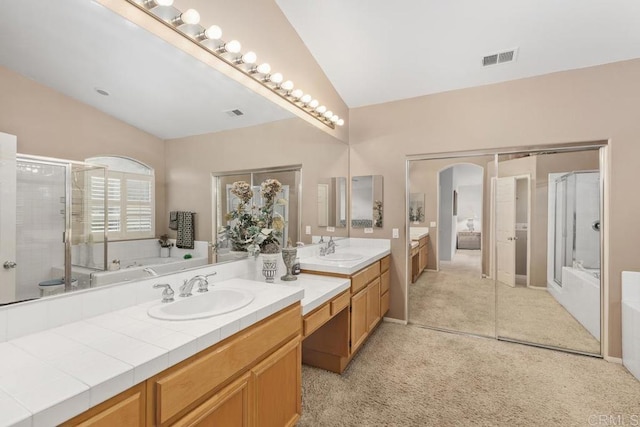 bathroom featuring visible vents, vanity, a shower stall, and vaulted ceiling