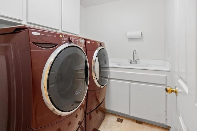 clothes washing area featuring a sink, cabinet space, and washer and clothes dryer