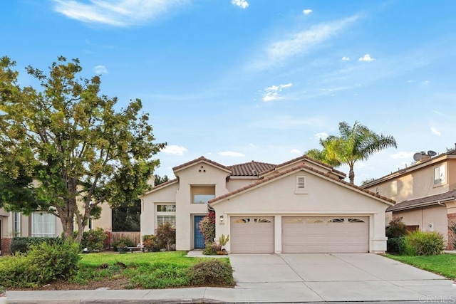 mediterranean / spanish-style house featuring a tiled roof, concrete driveway, a front yard, stucco siding, and an attached garage