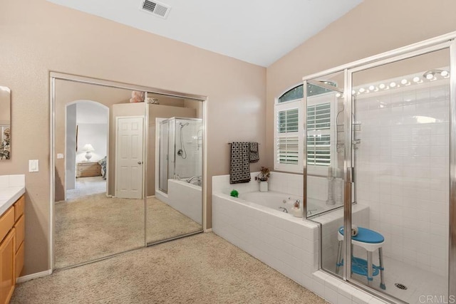 full bathroom with visible vents, a garden tub, a stall shower, lofted ceiling, and vanity