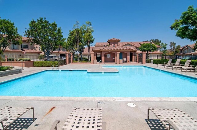 community pool featuring a patio area and fence