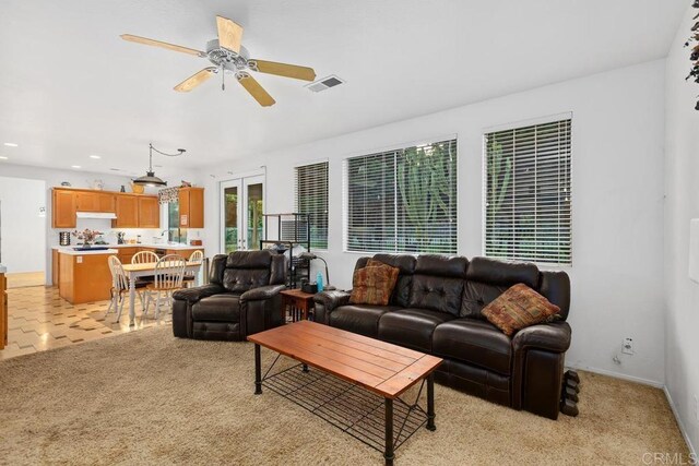 living room featuring visible vents, a ceiling fan, recessed lighting, baseboards, and light colored carpet