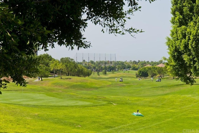 view of home's community featuring view of golf course and a yard