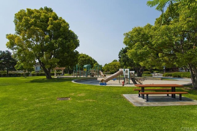 view of property's community with playground community and a lawn