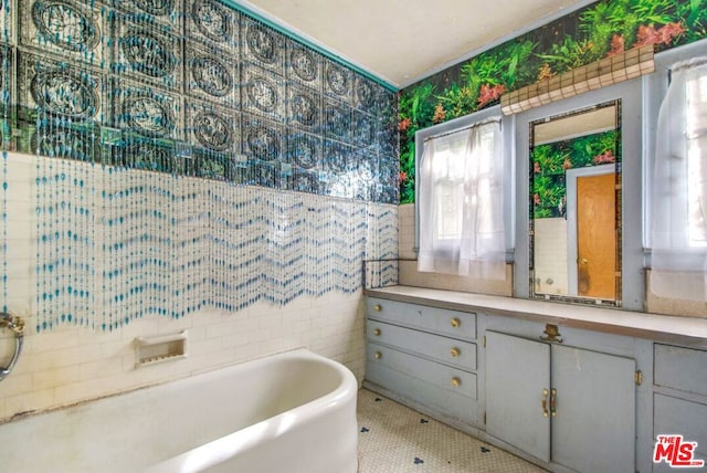 bathroom featuring a washtub and tile walls