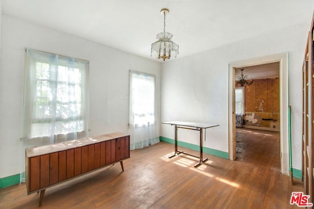 miscellaneous room with hardwood / wood-style flooring and a notable chandelier