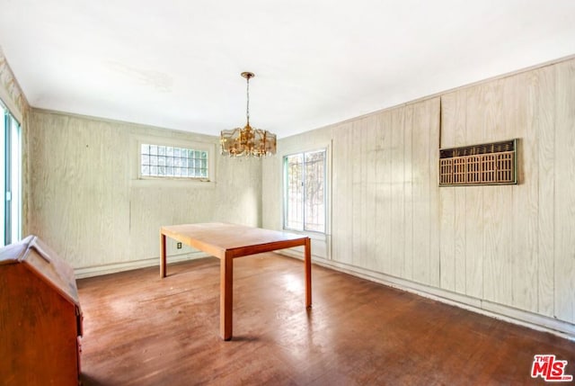 unfurnished dining area with dark hardwood / wood-style floors and an inviting chandelier