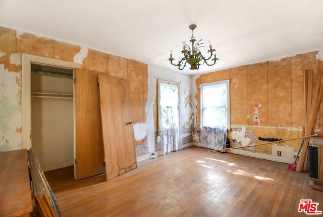 misc room with an inviting chandelier and hardwood / wood-style floors