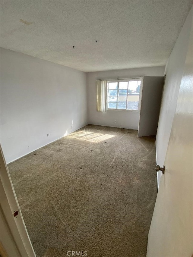 empty room featuring carpet floors and a textured ceiling