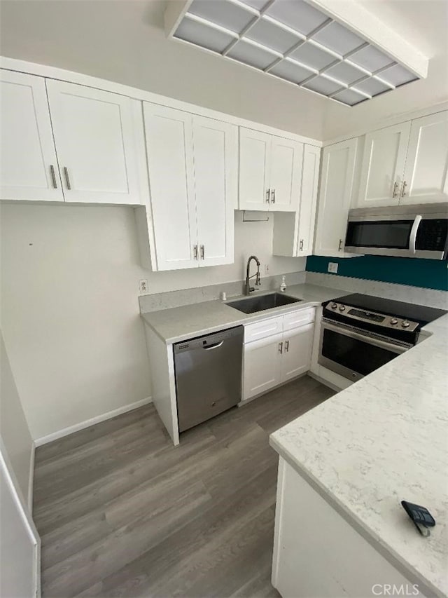 kitchen featuring stainless steel appliances, hardwood / wood-style flooring, sink, and white cabinets