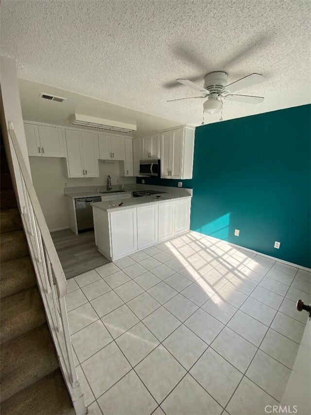 kitchen featuring appliances with stainless steel finishes, sink, white cabinets, ceiling fan, and kitchen peninsula