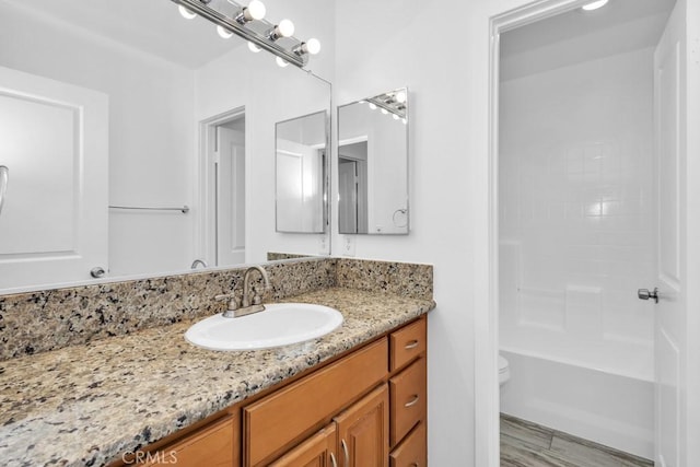 full bathroom featuring vanity, bathtub / shower combination, and toilet