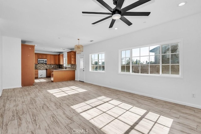 unfurnished living room with ceiling fan and light wood-type flooring