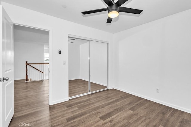 unfurnished bedroom with dark hardwood / wood-style floors, ceiling fan, and a closet