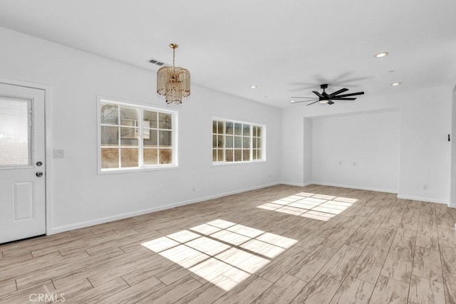 interior space with ceiling fan with notable chandelier and light hardwood / wood-style flooring