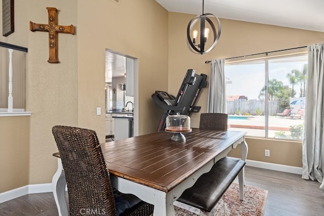 dining room with an inviting chandelier, lofted ceiling, and light hardwood / wood-style flooring