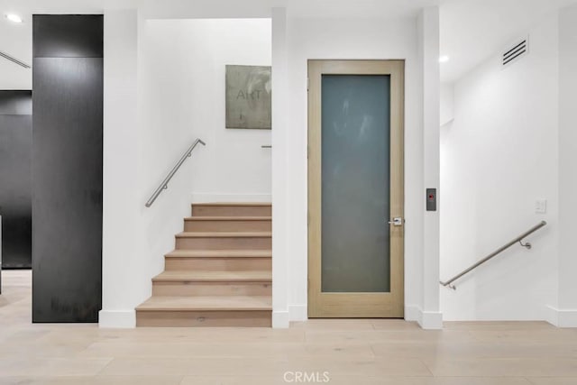 staircase with hardwood / wood-style flooring