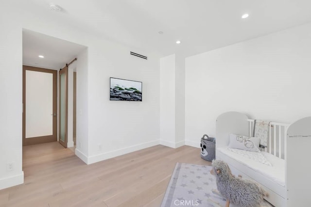 living area featuring light hardwood / wood-style flooring and a barn door