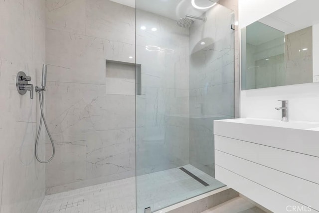 bathroom featuring vanity and tiled shower