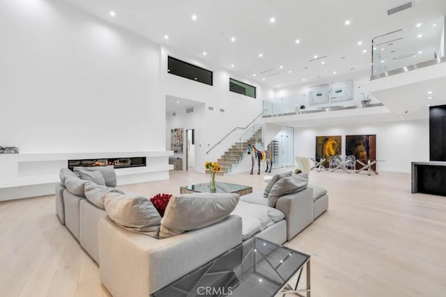 living room with a high ceiling and light wood-type flooring