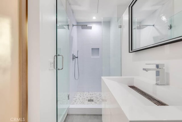 bathroom featuring walk in shower and sink