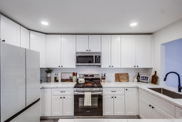 kitchen with white cabinetry, stainless steel appliances, and sink