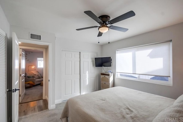 carpeted bedroom featuring ceiling fan and a closet