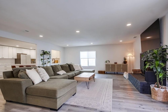 living room with a fireplace and light hardwood / wood-style floors