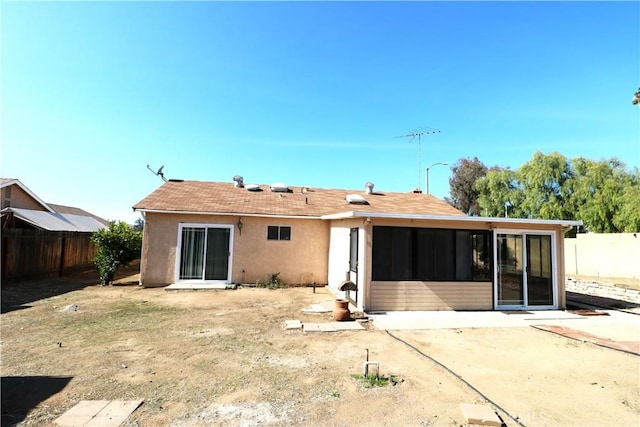 rear view of property featuring a patio and a sunroom