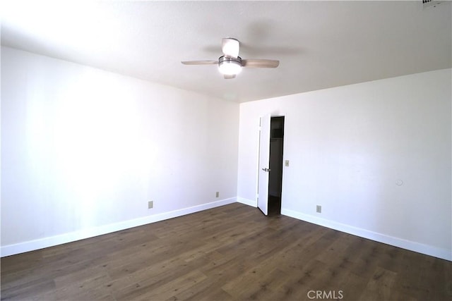 empty room featuring dark wood-type flooring and ceiling fan