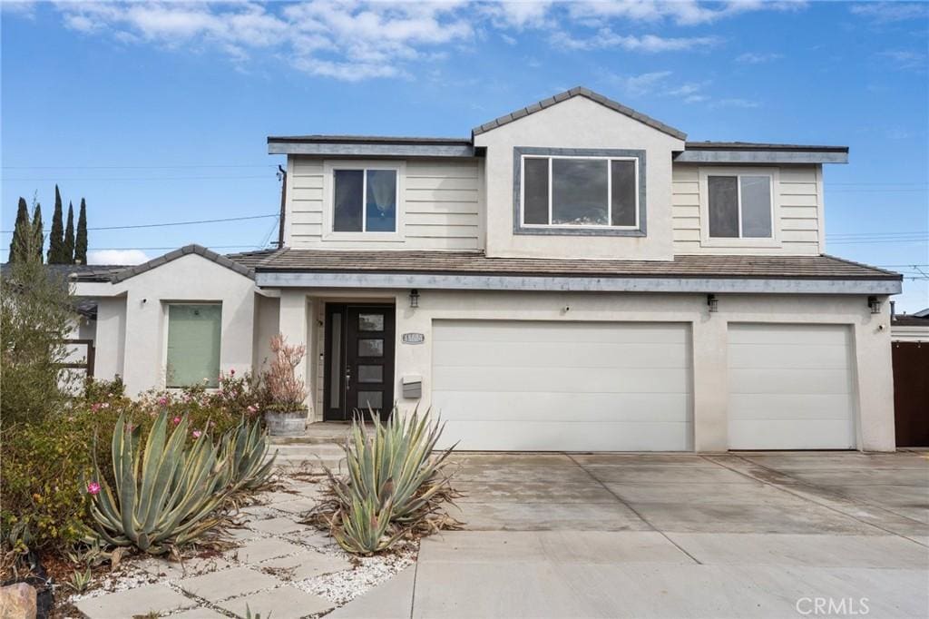 view of front of home with a garage, a shingled roof, concrete driveway, and stucco siding