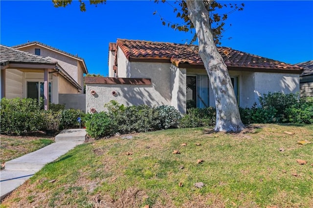 mediterranean / spanish-style home featuring a front yard