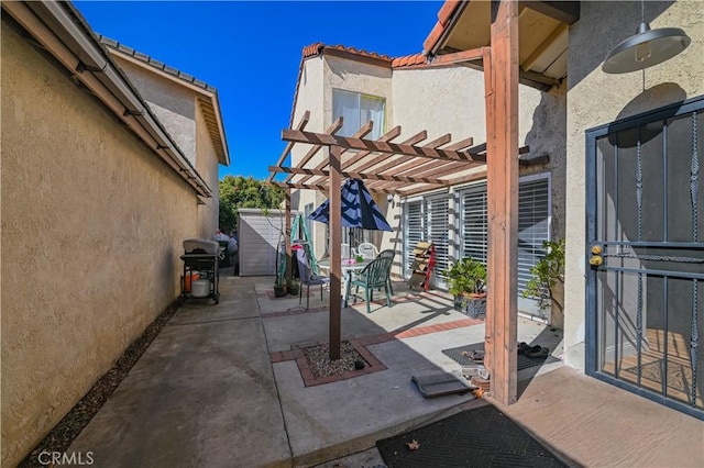 view of patio with a storage unit, a grill, and a pergola