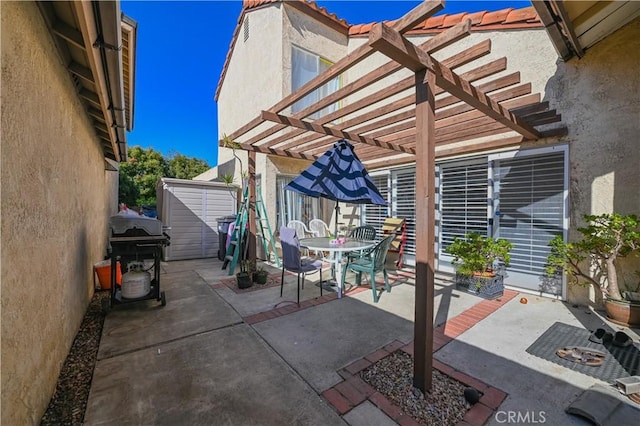 view of patio / terrace with area for grilling, a storage shed, and a pergola