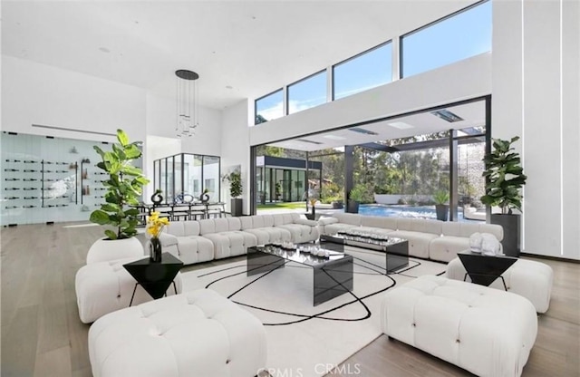 living room with hardwood / wood-style flooring, a towering ceiling, and a wealth of natural light