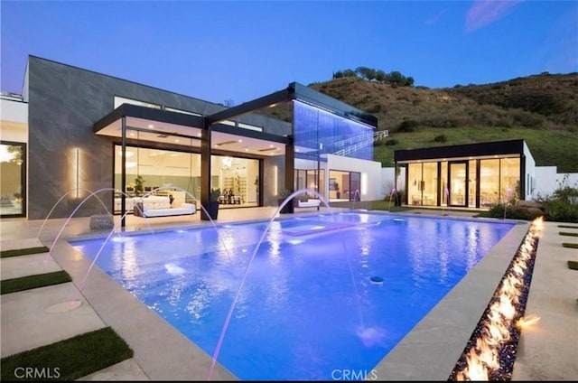 view of swimming pool with pool water feature and an outdoor structure