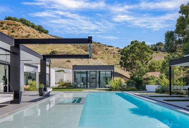 back of house featuring a fenced in pool, a patio, and a mountain view