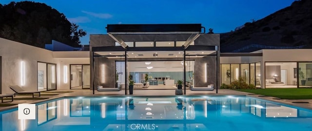 pool at twilight featuring a patio area