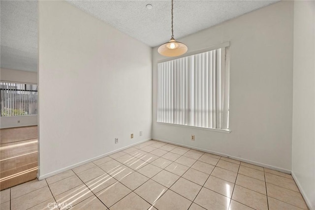 tiled empty room with a textured ceiling