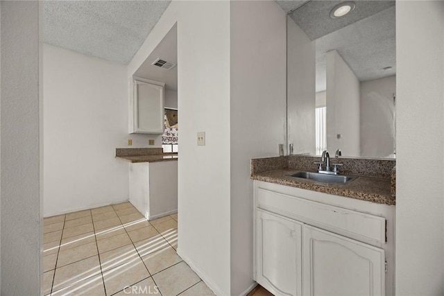 bathroom featuring vanity, tile patterned floors, and a textured ceiling