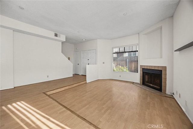 unfurnished living room featuring wood-type flooring and a fireplace