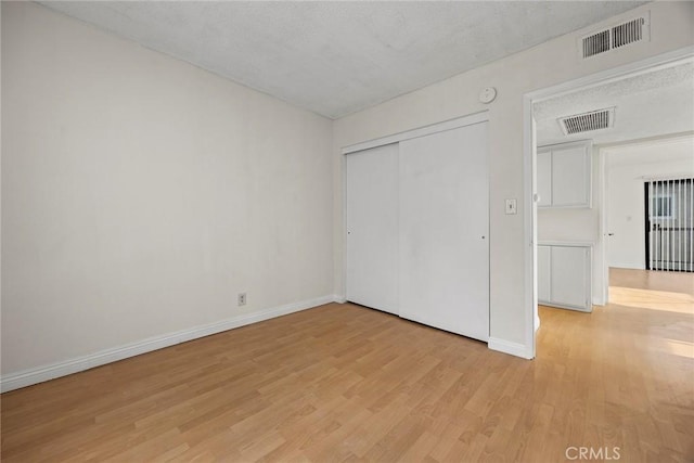 unfurnished bedroom with light hardwood / wood-style floors and a closet