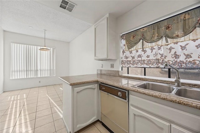 kitchen with dishwasher, sink, white cabinets, light tile patterned floors, and kitchen peninsula