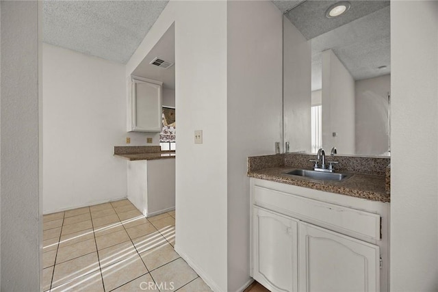 bathroom featuring vanity, tile patterned flooring, and a textured ceiling