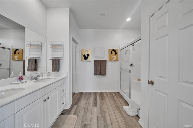 bathroom with vanity, a shower with door, and hardwood / wood-style floors