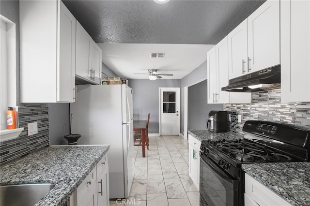 kitchen with dark stone countertops, ceiling fan, gas stove, and white cabinets