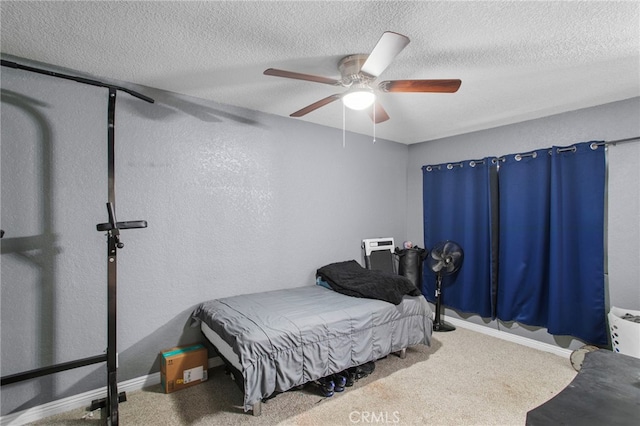 bedroom with ceiling fan, carpet, and a textured ceiling